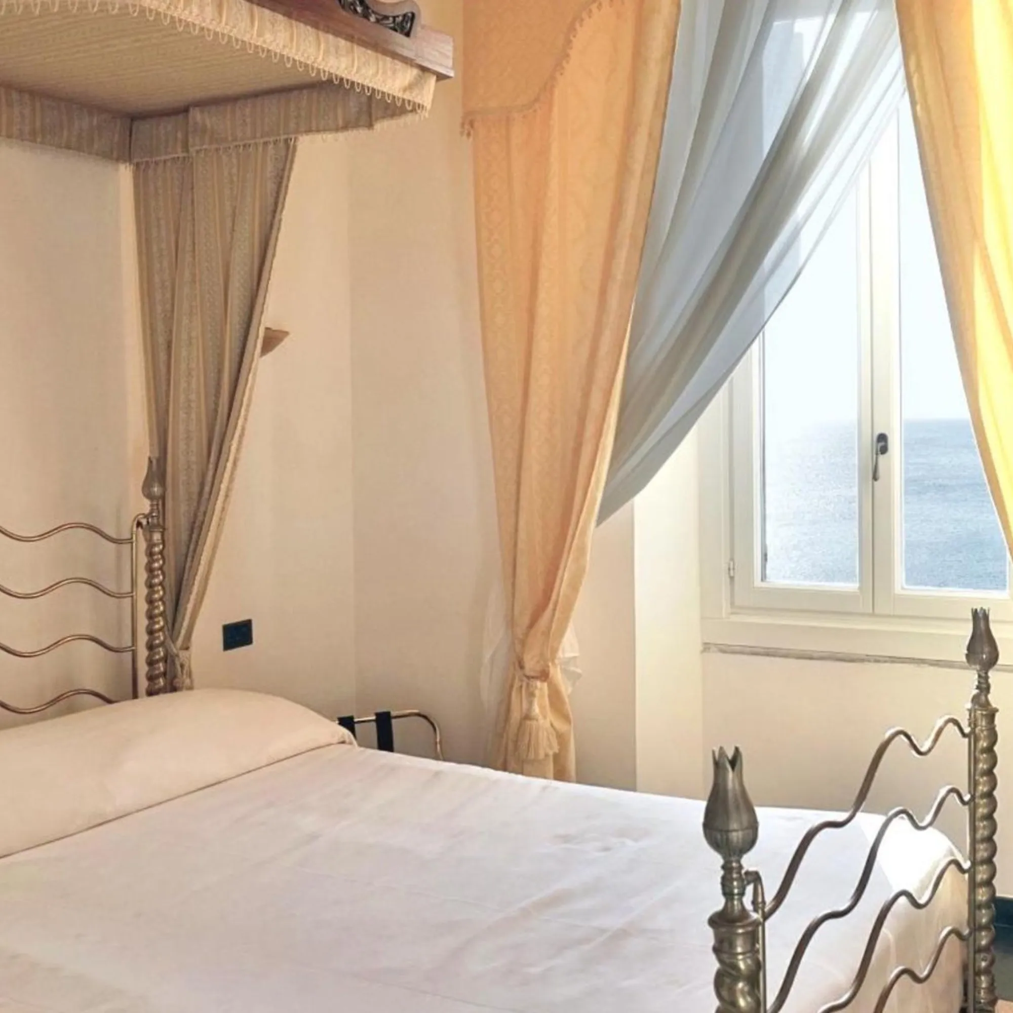 Camera singola di lusso di Villa Las Tronas Hotel & Spa ad Alghero, con letto a baldacchino e finestra panoramica vista mare.