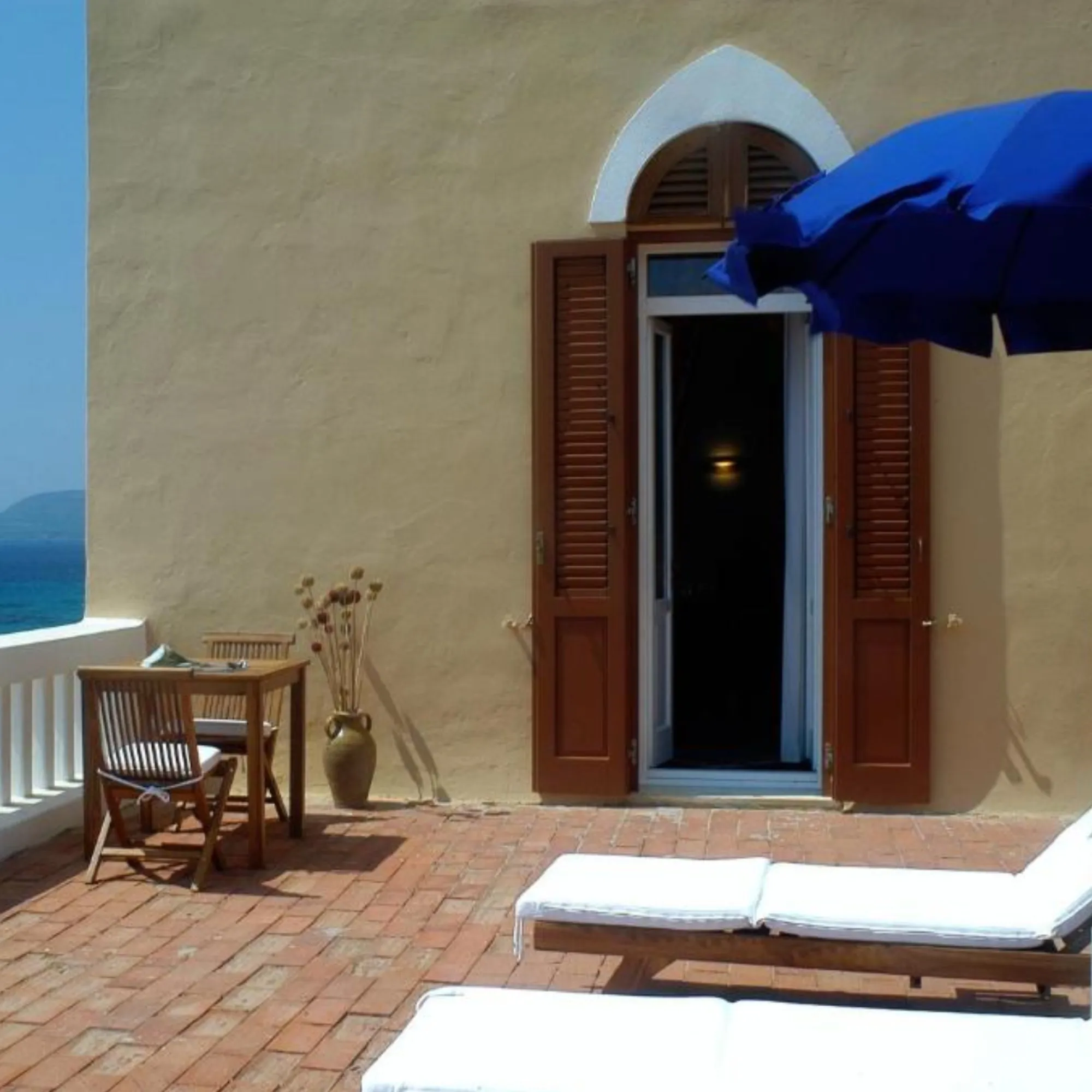 Ampia terrazza privata con solarium di Villa Las Tronas Hotel & Spa ad Alghero, arredi in teak e vista mare.