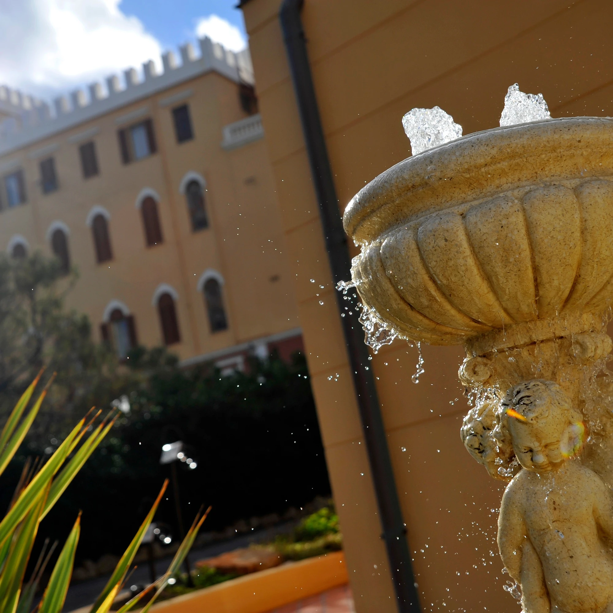 Fontana classica con putti nei giardini di Villa Las Tronas Hotel & Spa, con architettura storica e vegetazione mediterranea.