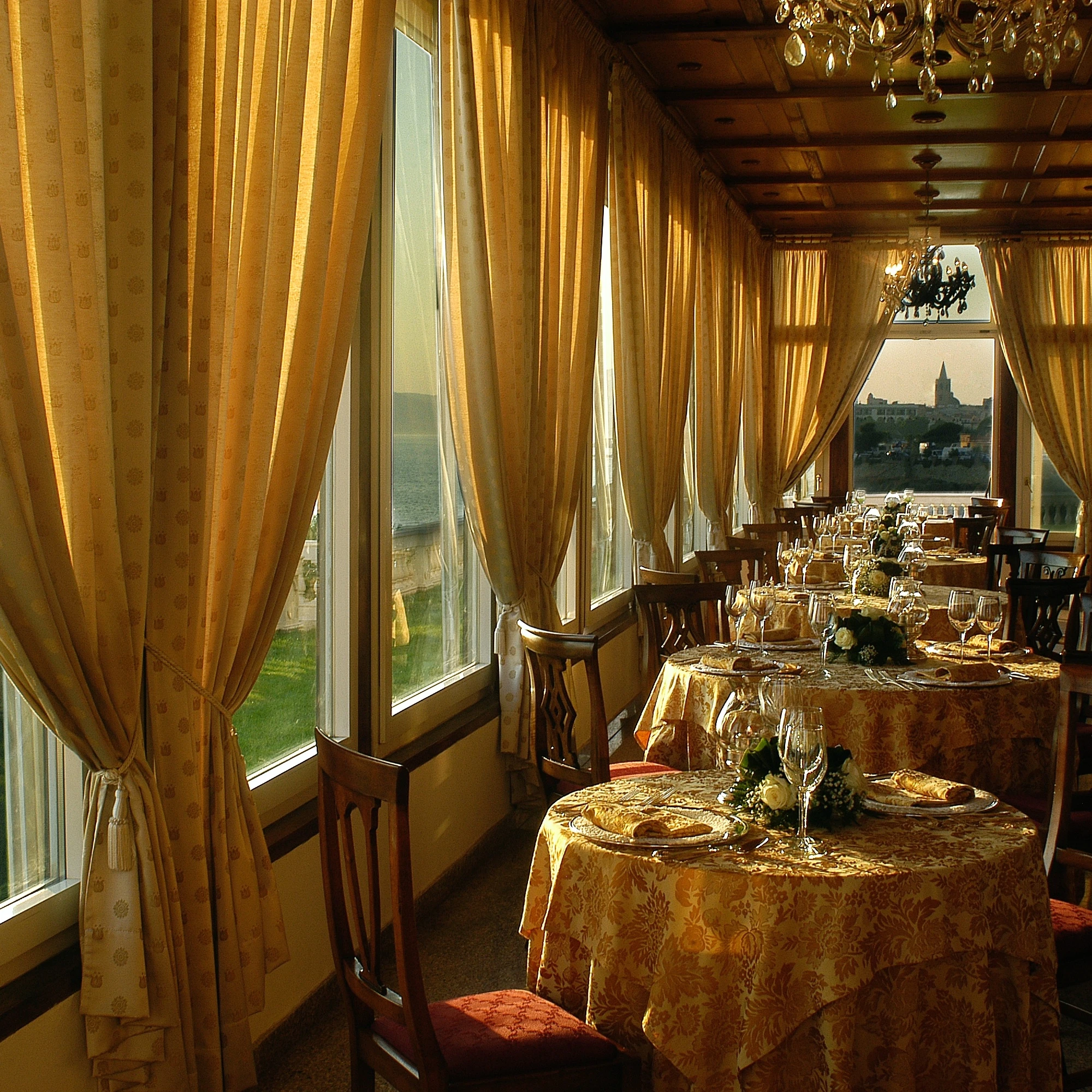 Ristorante di lusso presso Villa Las Tronas Hotel & Spa ad Alghero, sala con vista panoramica sul mare e sulla città antica.