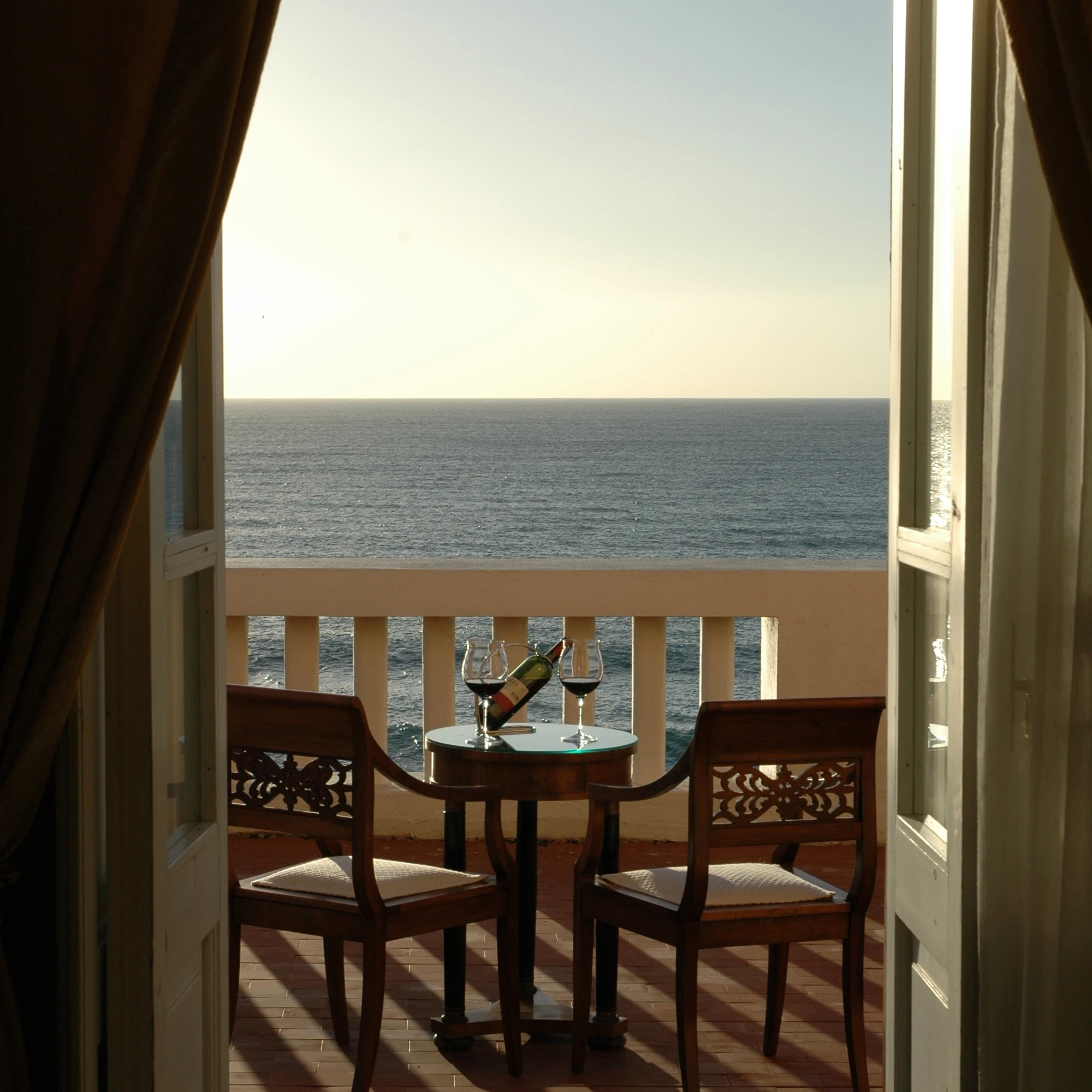 Balcone privato di Villa Las Tronas Hotel & Spa ad Alghero, set per aperitivo romantico vista mare al tramonto.